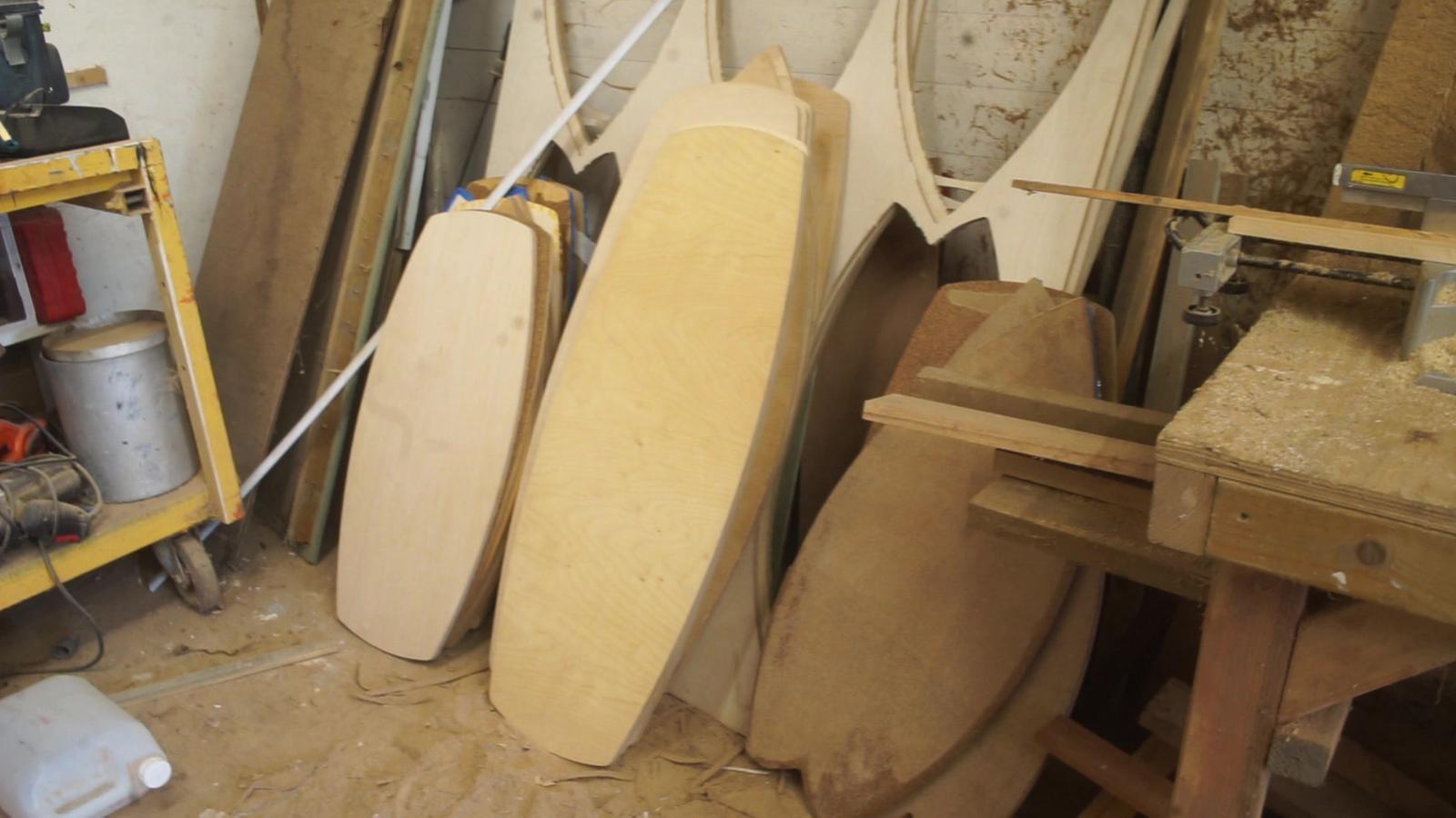 A stack of board blanks leaning in the workshop.