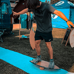 A rider balancing on a Norst board and roller at an outdoor event
