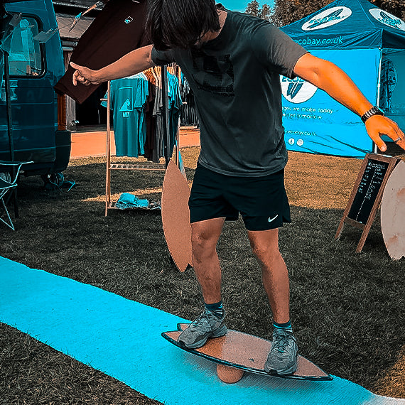 A rider balancing on a Norst board and roller at an outdoor event