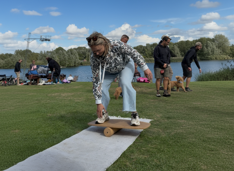 A demo day at a wake park, with a person stepping onto a board on a mat.