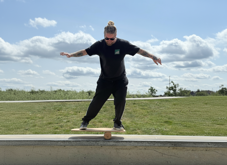 Jon balancing on a board at a skatepark.
