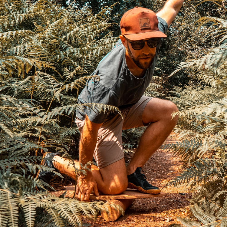 The Norst Surf Balance Board in use on its roller among ferns
