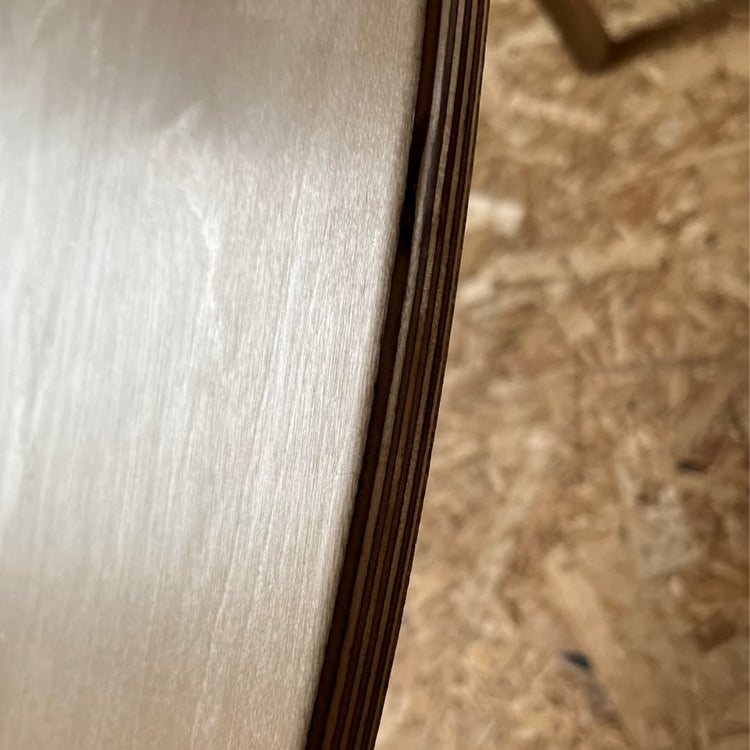 Close-up of a Norst board edge, birch plywood layers under the cork deck