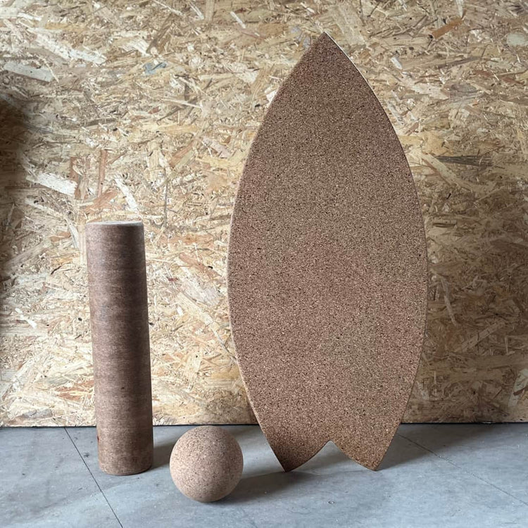 A Norst Surf Balance Board standing upright with a cork roller and cork ball