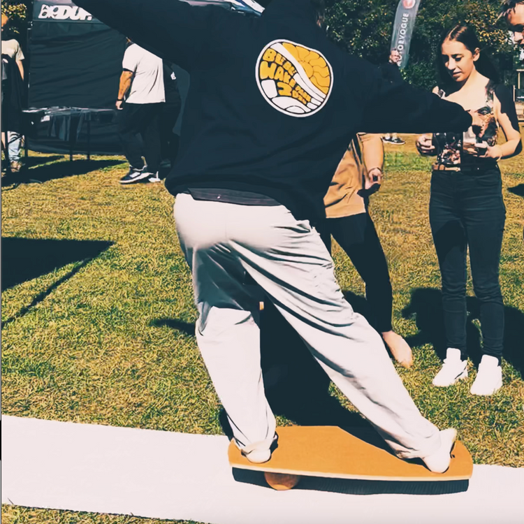 A rider balancing on a Norst Freestyle Balance Board and roller at an outdoor event