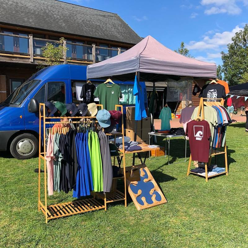 A Norst stall on the grass with clothing on a rail.