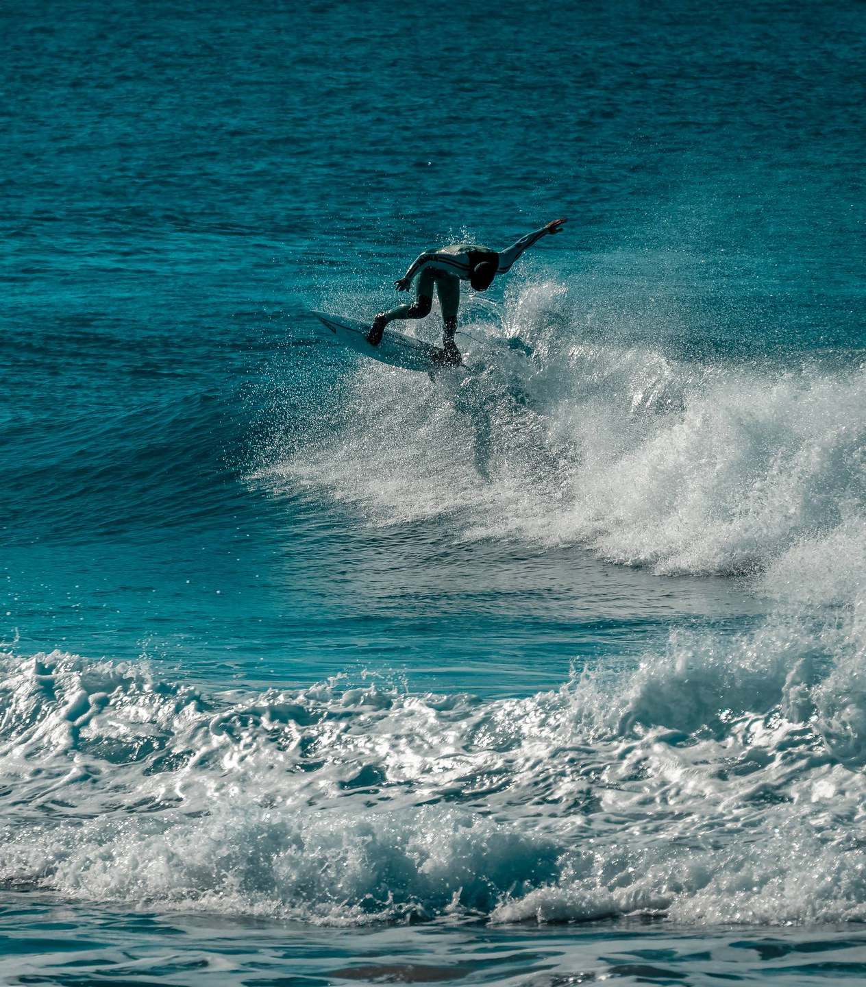 A surfer launching off a breaking wave at Peniche, Portugal