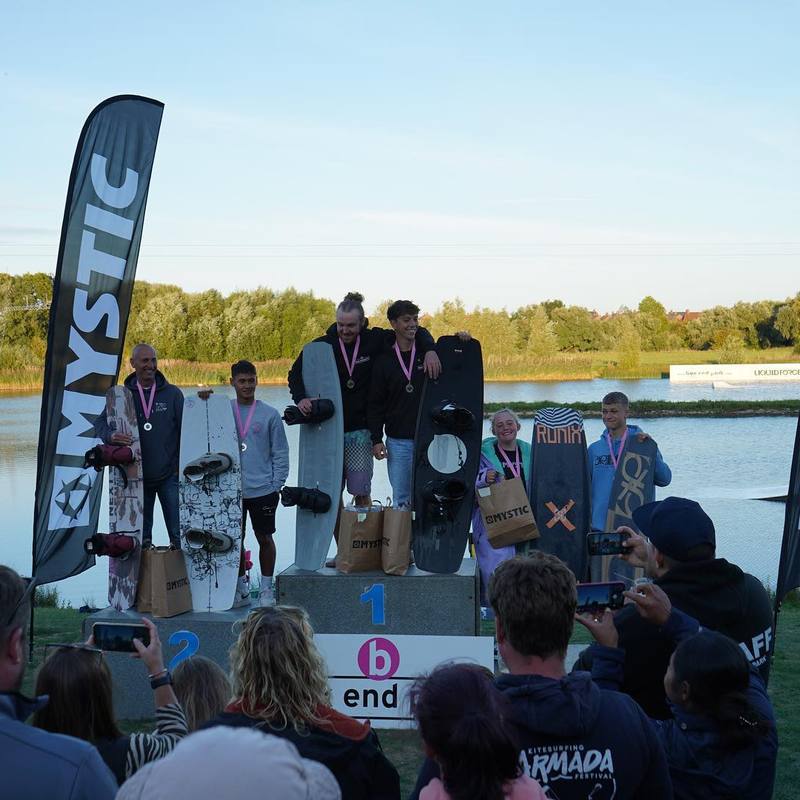 A group of people on a wakeboard park platform.